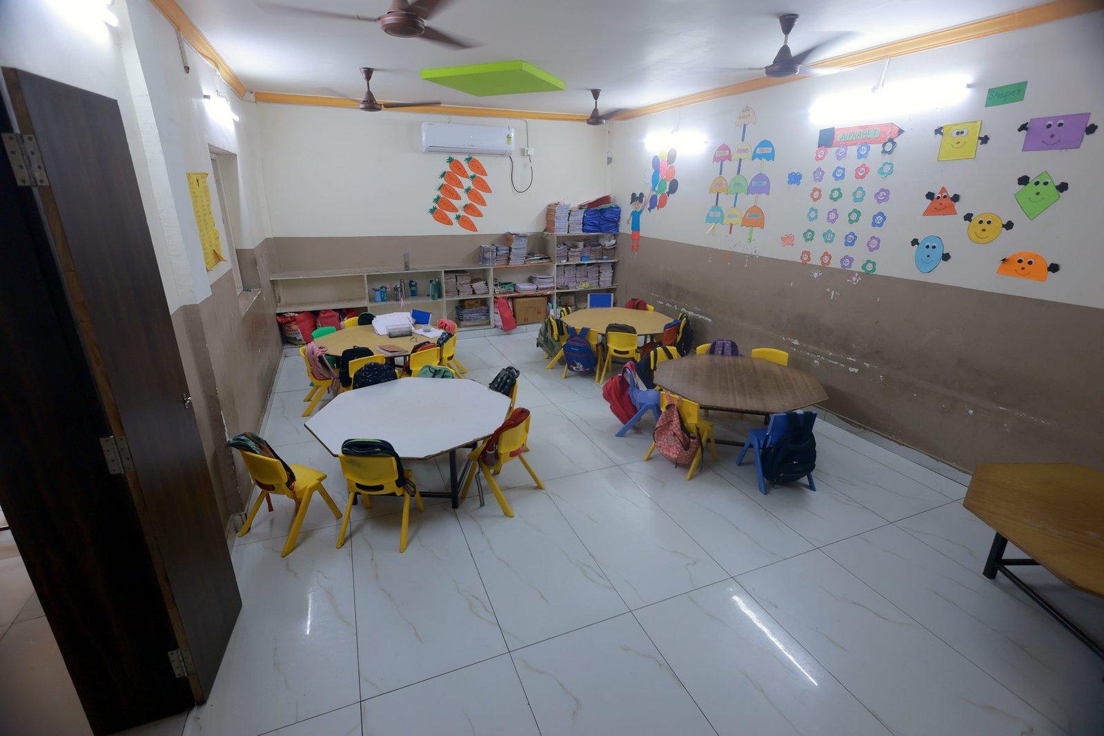 A preschool classroom with small tables and colourful walls