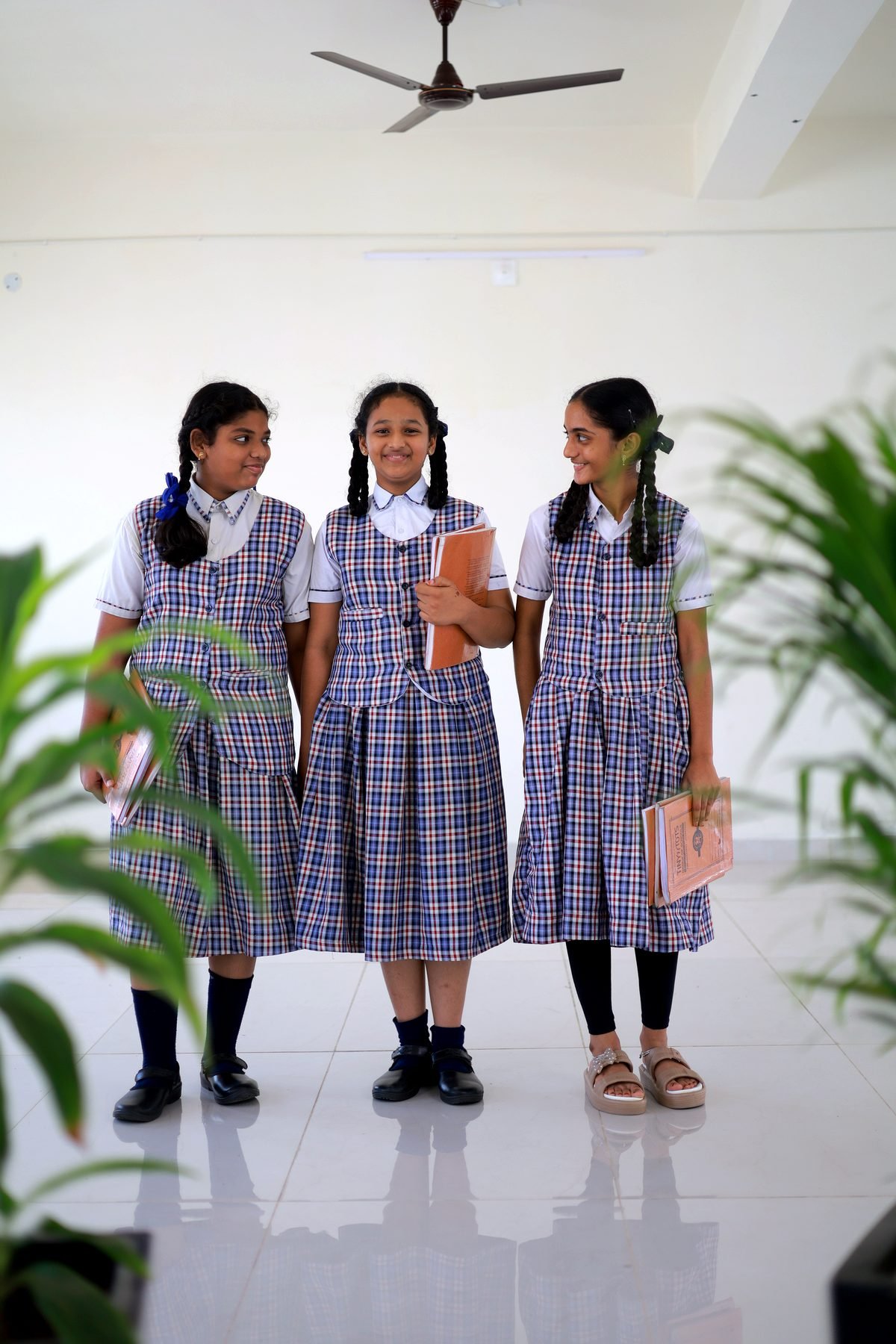 Three Tiny Tots students holding their books